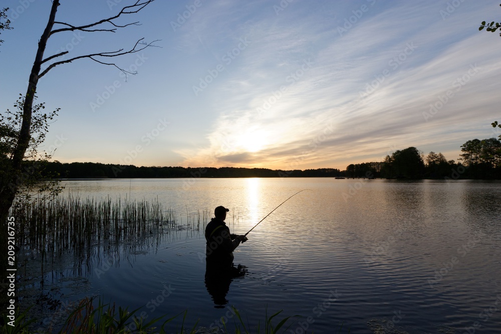 Silhouette of fisherman standing in the lake and catching the fish during sunrise
Silhouette of fisherman standing in the lake and catching the fish during sunrise