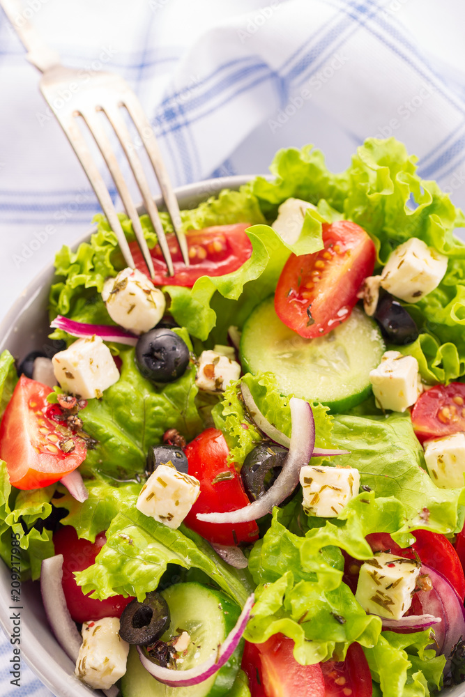 Fresh greek salad served in bowl with fork. Fresh greek salad served in bowl with fork.