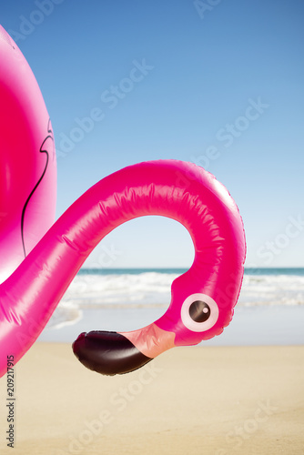 pink flamingo swim ring on the beach