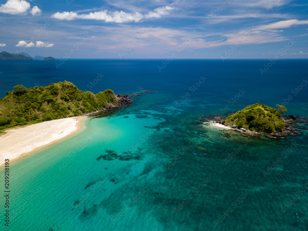 Aerial drone view of an empty, beautiful tropical beach surrounded by coral reef and greenery (Nacpan Beach, Palawan)