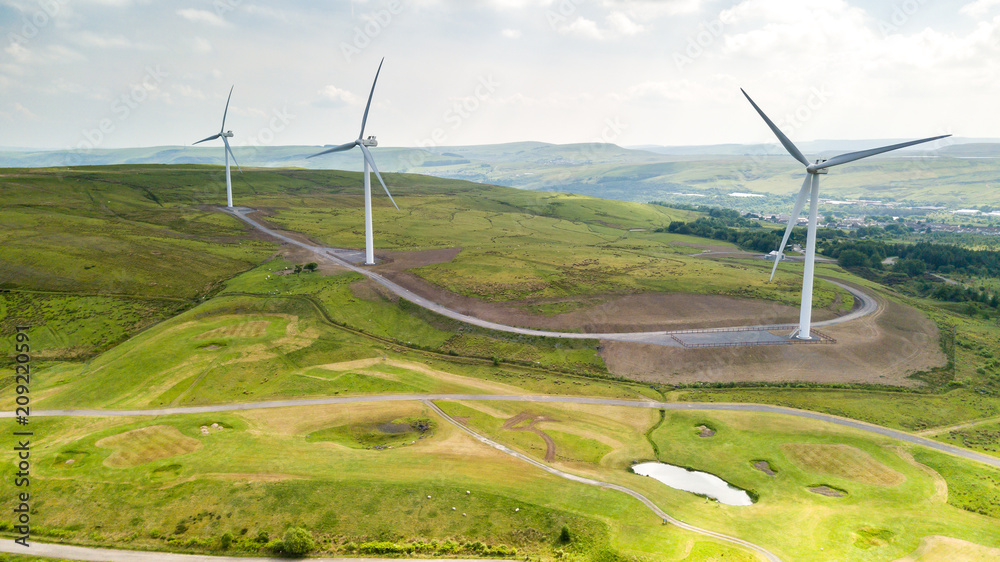 Aerial view of large wind turbines on a rural hillside in Wales Aerial view of large wind turbines on a rural hillside in Wales