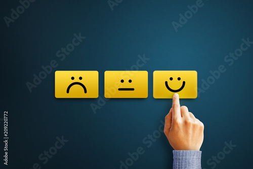 Hand of client show a feedback with smiley face card. Service rating, satisfaction concept photo