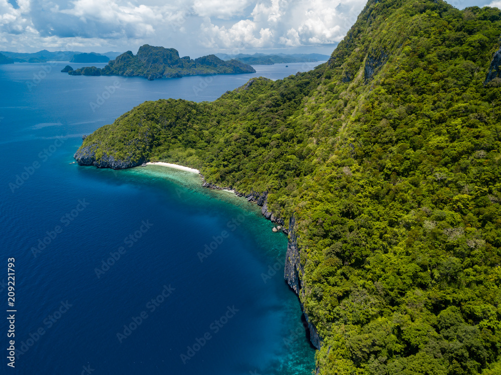 Obraz premium Aerial drone view of spectacular limestone cliffs, jungle, sandy beaches surrounded by coral reef