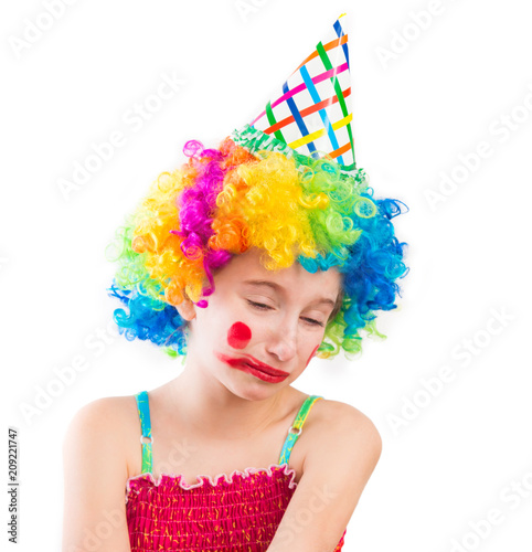 Upset little girl in clown wig and smeared make up isolated on white background