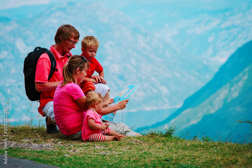 family with kids travel in mountains, tourists looking at map, vacation