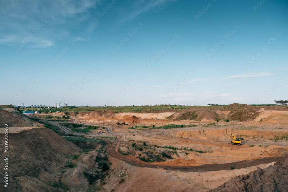 Industrial sand quarry with hydraulic excavator machinery. Beautiful industrial landscape, construction industry