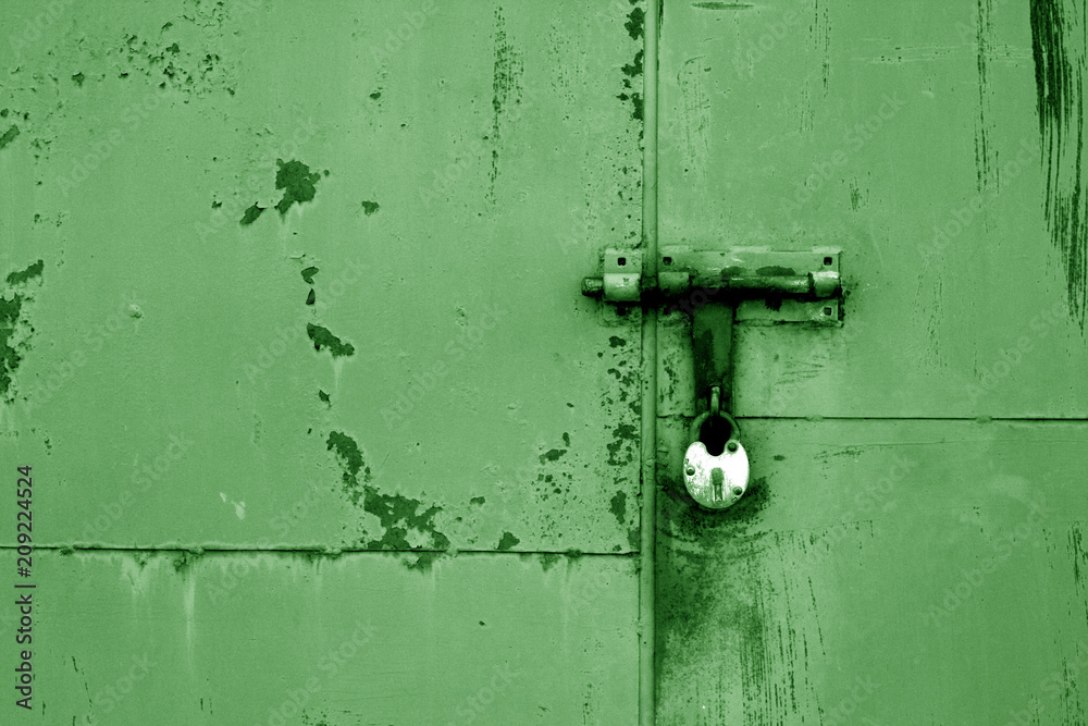 Old padlock on metal gate in green color. Old padlock on metal gate in green color.