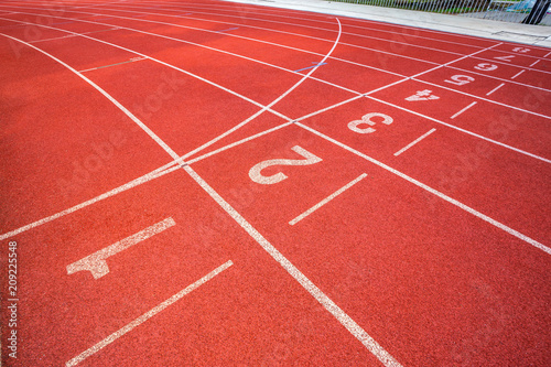 White lines of stadium and texture of running racetrack red rubber racetracks in outdoor stadium are 8 track and green grass field empty athletics stadium with track football field  soccer field.