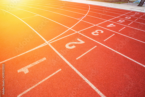 White lines of stadium and texture of running racetrack red rubber racetracks in outdoor stadium are 8 track and green grass field empty athletics stadium with track football field  soccer field.