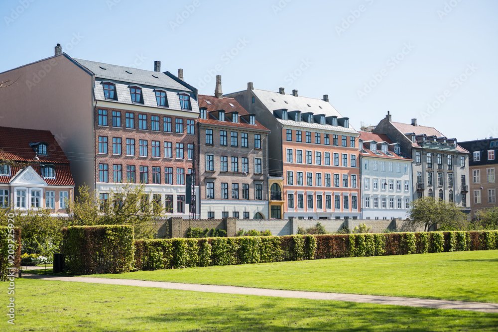 beautiful green lawn with bushes and old houses in copenhagen, denmark