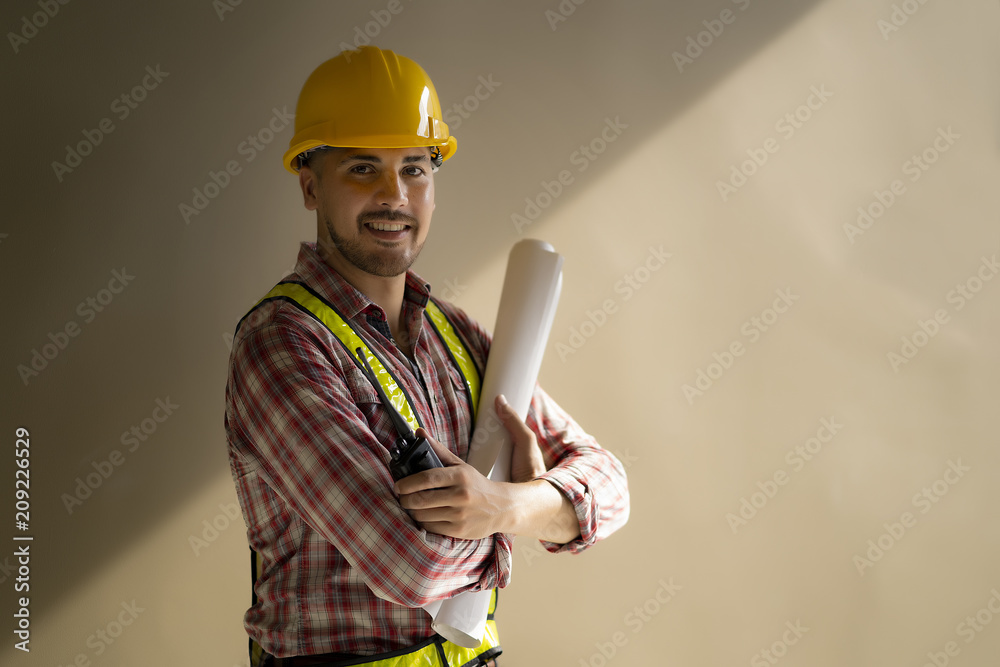 Young engineer working with blueprint at a construction site. Young engineer working with blueprint at a construction site.