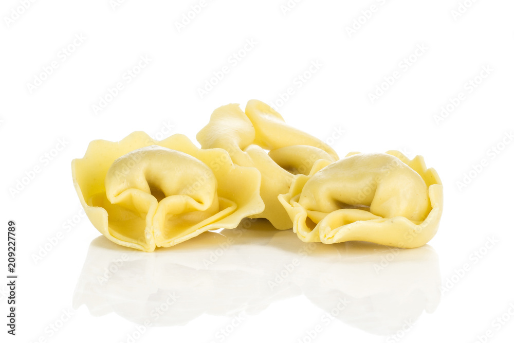 Three raw tortellini pasta isolated on white background Italian.