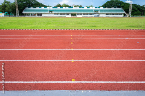 White lines of stadium and texture of running racetrack red rubber racetracks in outdoor stadium are 8 track and green grass field,empty athletics stadium with track.