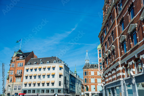 cityscape with buildings under bright blue sky in Copenhagen, Denmark
