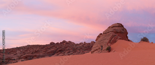 Sunrise clouds, sandstone rocks and sand dunes lit by predawn light