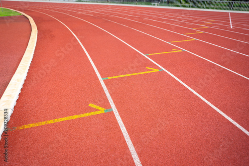 White lines of stadium and texture of running racetrack red rubber racetracks in outdoor stadium are 8 track and green grass field,empty athletics stadium with track.