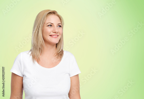 body positive and people concept - happy woman in white t-shirt over lime green natural background