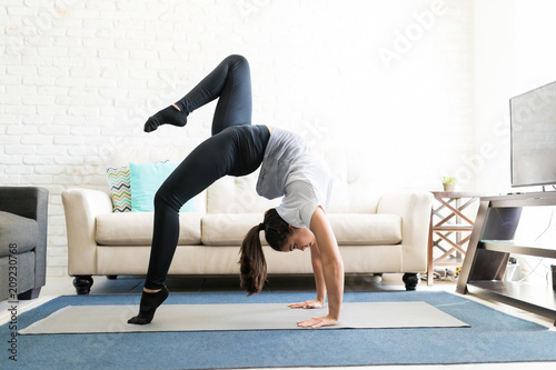 Woman trying new yoga pose at home