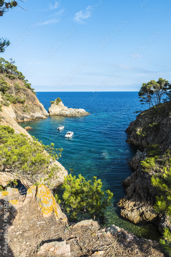 Yacht next to cliff in the Costa Brava, Catalonia, Spain