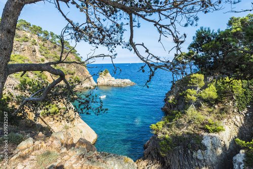 Yacht next to cliff in the Costa Brava, Catalonia, Spain photo