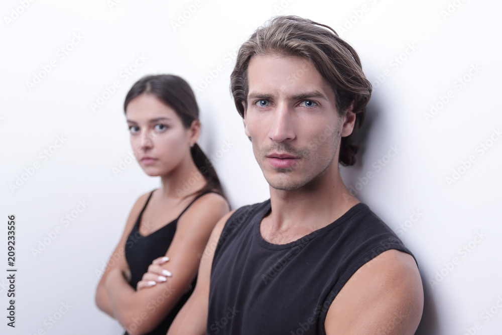 serious young couple standing near the wall serious young couple standing near the wall