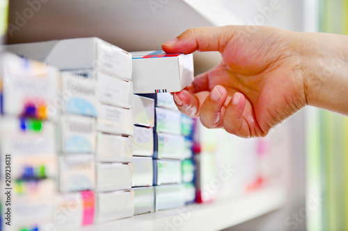 Closeup pharmacist hand holding medicine box in pharmacy drugstore. photo
