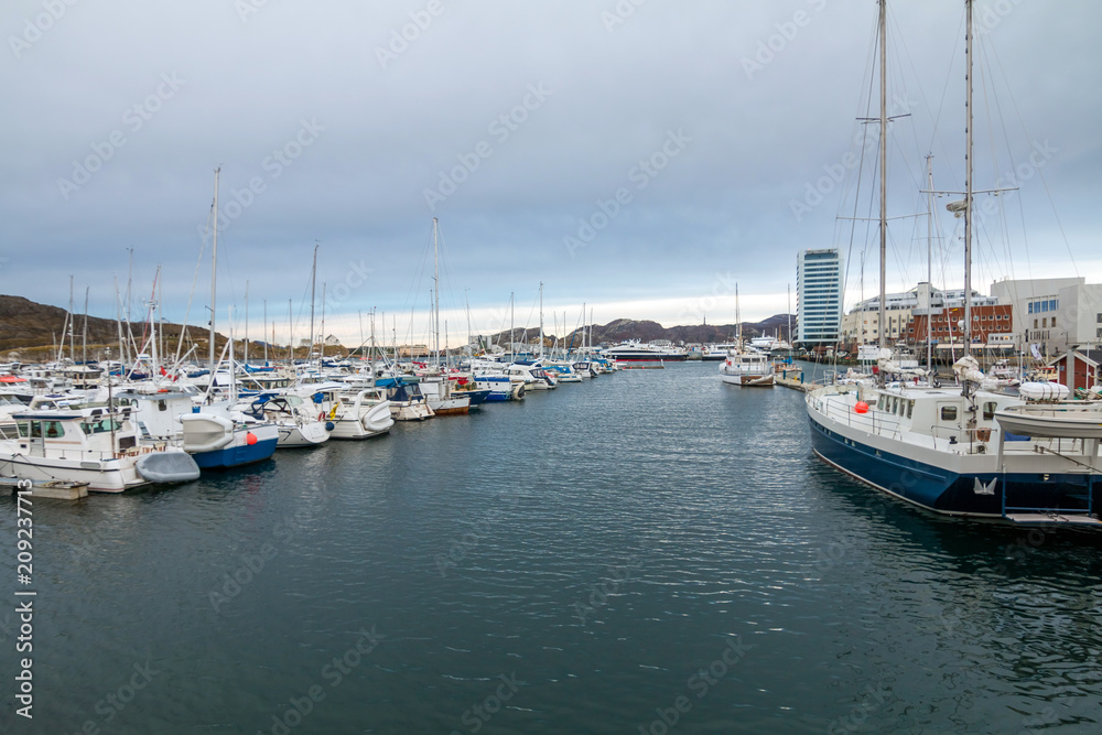 View of the marina and port in Bodo at evening. Norway. Skyline of city. Hotels in background