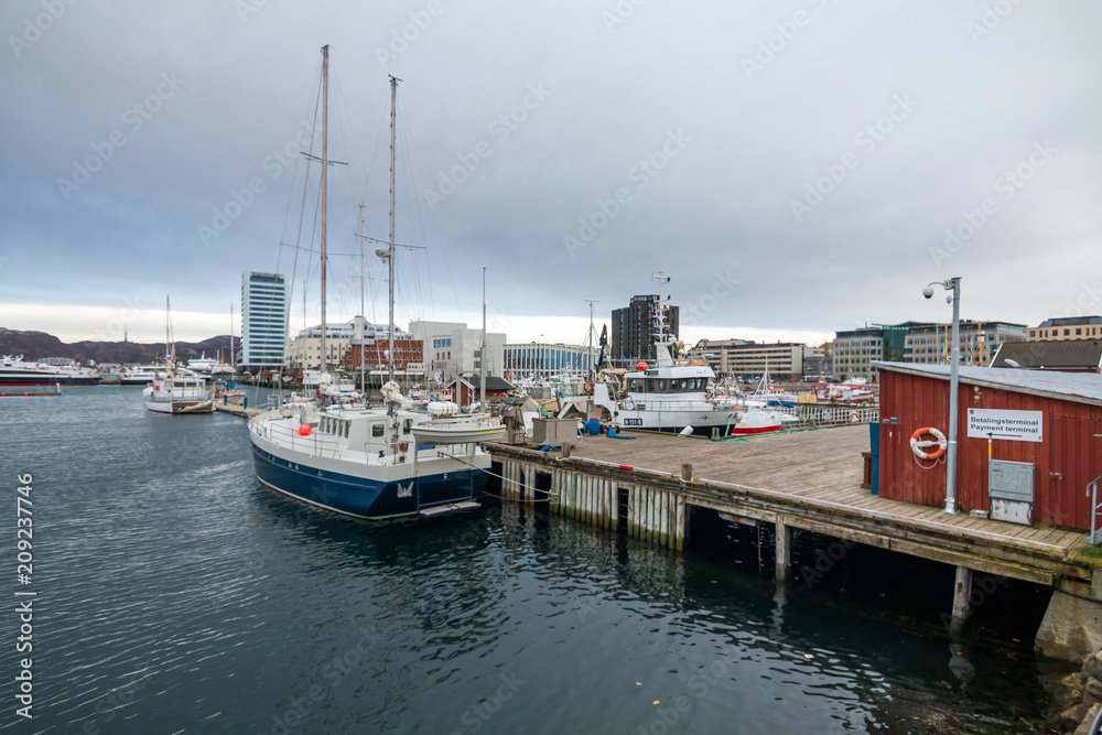 View of the marina and port in Bodo at evening. Norway. Skyline of city. Hotels in background