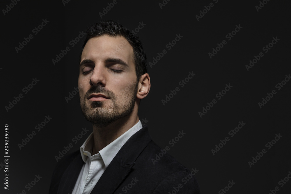 old style man, in elegant suit, isolated on dark background, portrait of an elegant businessman with closed eyes focuses on the challenges to be faced old style man, in elegant suit, isolated on dark background, portrait of an elegant businessman with closed eyes focuses on the challenges to be faced