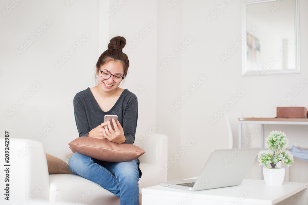 Young beautiful woman using smart phone on sofa Young beautiful woman using smart phone on sofa