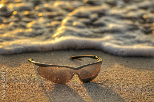 lentes de sol sobre la arena en la playa photo