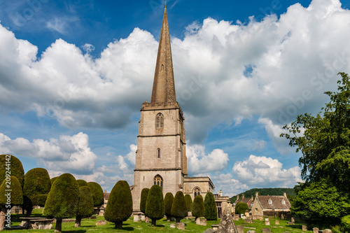 An ancient church and graveyard in the scenic Cotswolds area of England on a summers day (Painswick) photo