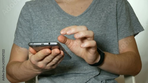 man uses a smartphone and clock