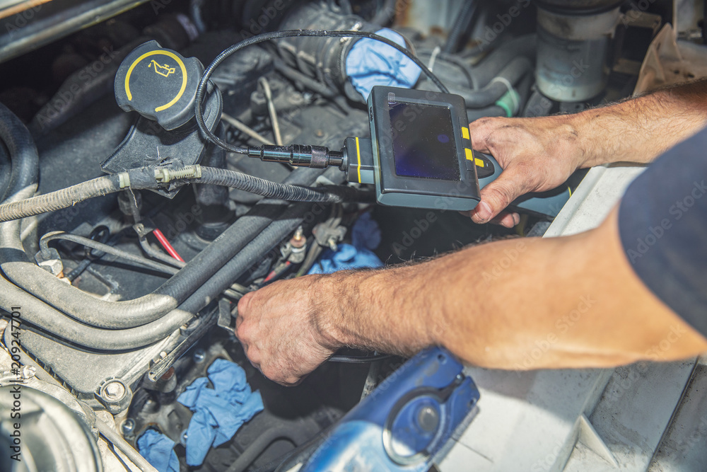 mechanic inspecting car engine with video borescope camera mechanic inspecting car engine with video borescope camera