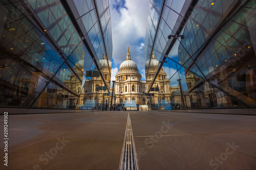 London, England - Beautiful St.Paul's Cathedral reflected in glass windows in the morning sunlight with blue sky and clouds