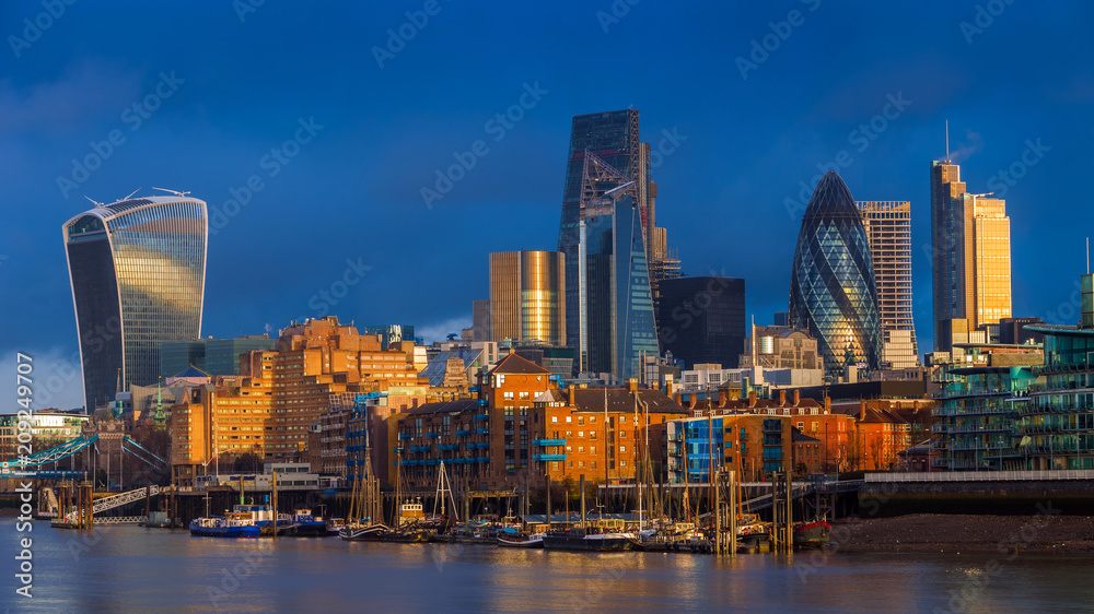 London, England - Beautiful dramatic sky and golden hour sunlight at Bank District of London with famous skyscrapers