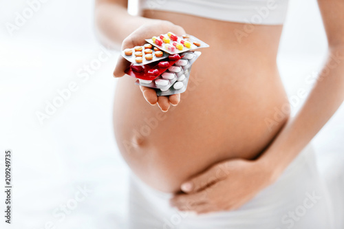 Pregnancy Vitamins And Medications. Pregnant Woman With Pills photo