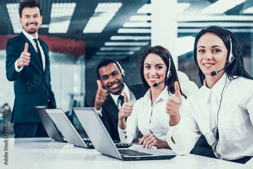 Happy multiracial call center team shows thumbs up