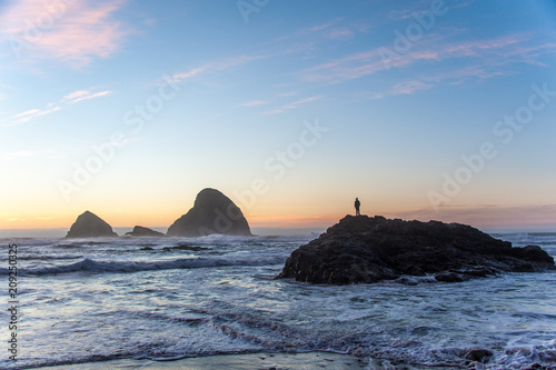 Man standing on a rock at sunset