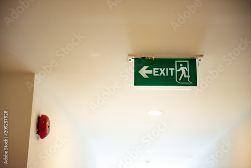 Emergency exit sign with red fire alarm