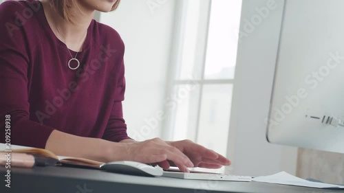 Beautiful woman is working in the office and quickly typing on the computer keyboard. Text or message typing. Concept text, work, office work. Business correspondence. Secretary.