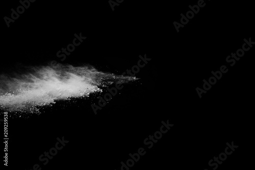  Freeze motion of white dust explosion on black background. Stopping the movement of white powder on dark background. Explosive powder white on black background.