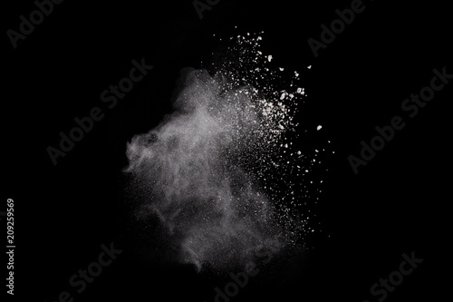  Freeze motion of white dust explosion on black background. Stopping the movement of white powder on dark background. Explosive powder white on black background.