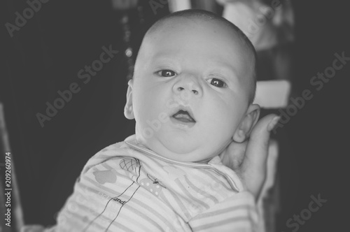  black and white photo a baby yawns on his hand