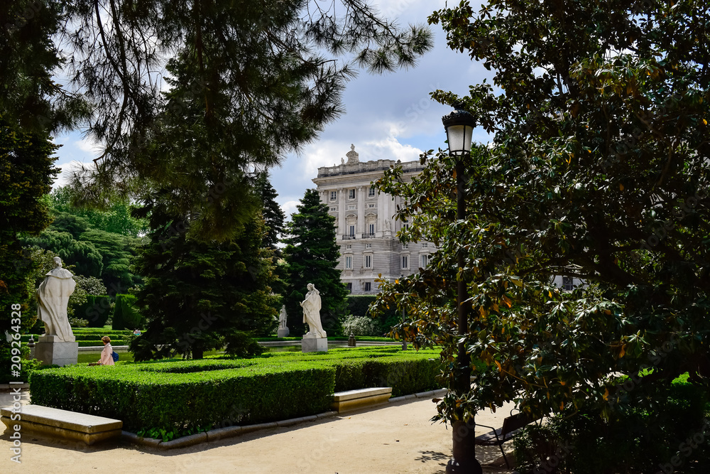 The Royal Palace of Madrid seen through several of its trees. Photograph taken in the gardens of Sabatini in Madrid at the Royal Palace (Spain)