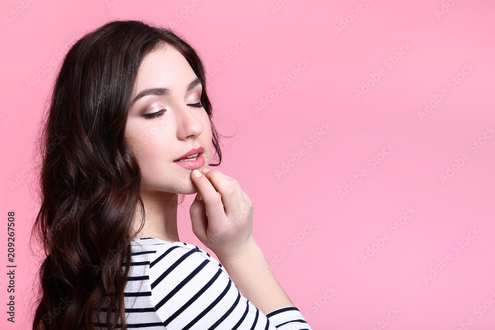 Portrait of young woman in striped blouse on pink background Portrait of young woman in striped blouse on pink background