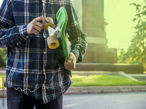 close up person in the summer street with penny skateboard on a sunny day photo