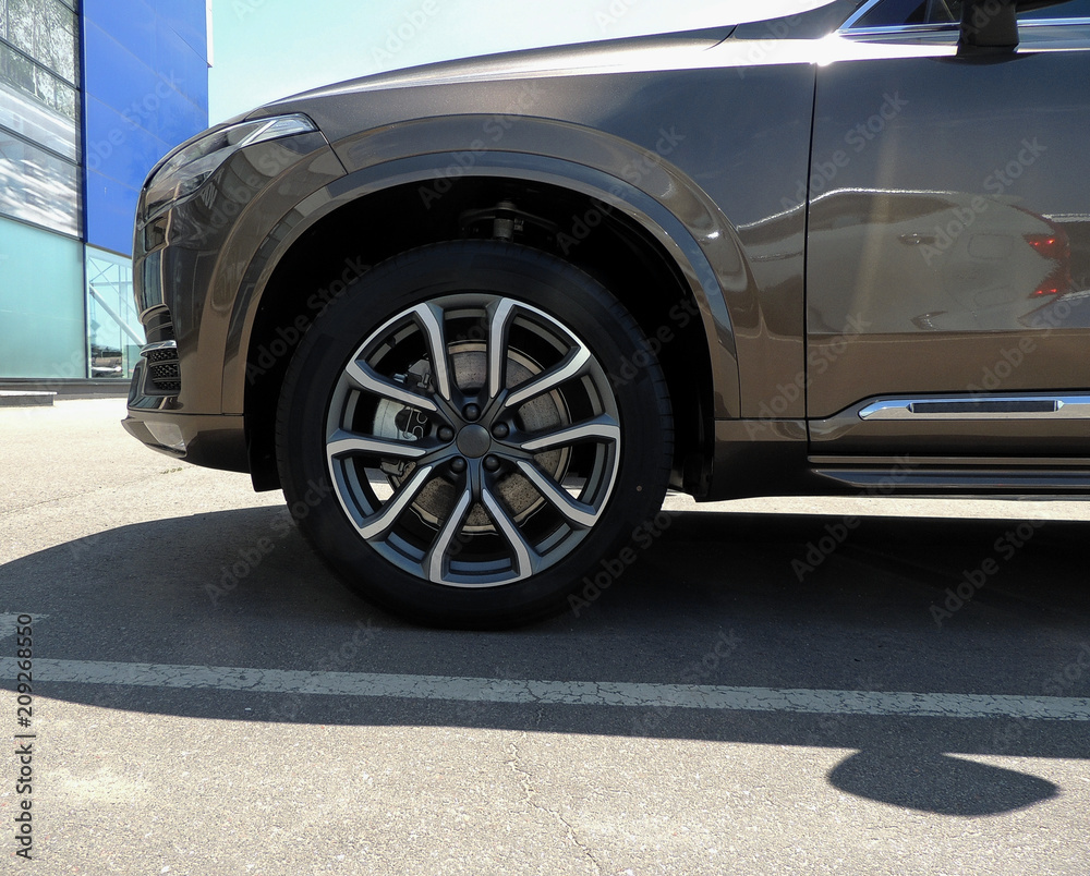 Front wheel of vehicle stay along the marking line at car parking in front of business center 
