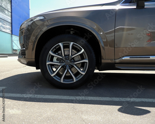 Front wheel of vehicle stay along the marking line at car parking in front of business center    © AnyVIDStudio