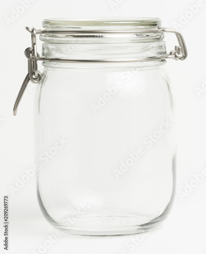 Empty glass food preserving jar in a white kitchen. Potential copy space inside jar.